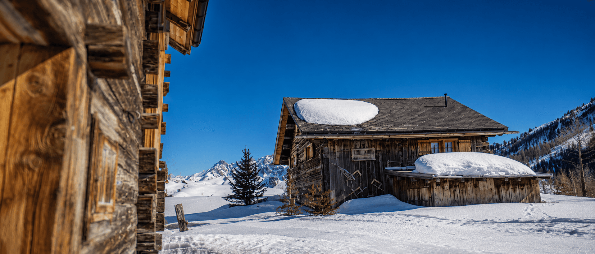 Das verschneite Maiensäss Acla Viglia im Tiefwinter mit Bergkette