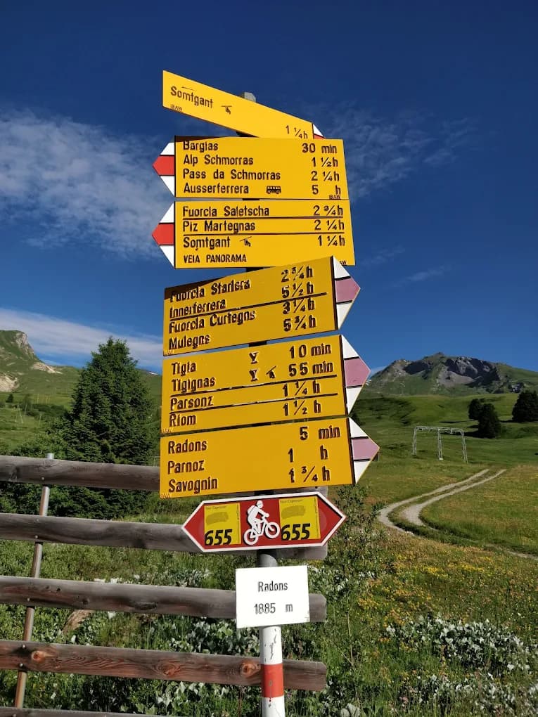 Gelber Wanderwegweiser in Radons auf 1885 Metern mit Zielen Alp Schmorras, Piz Martegnas und Savognin